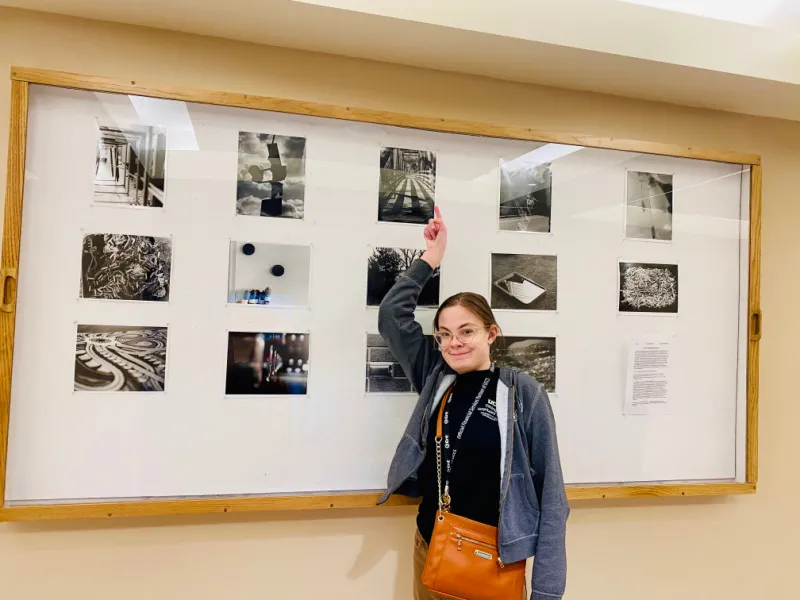 Sam shows of her photos in a gallery on the wall.