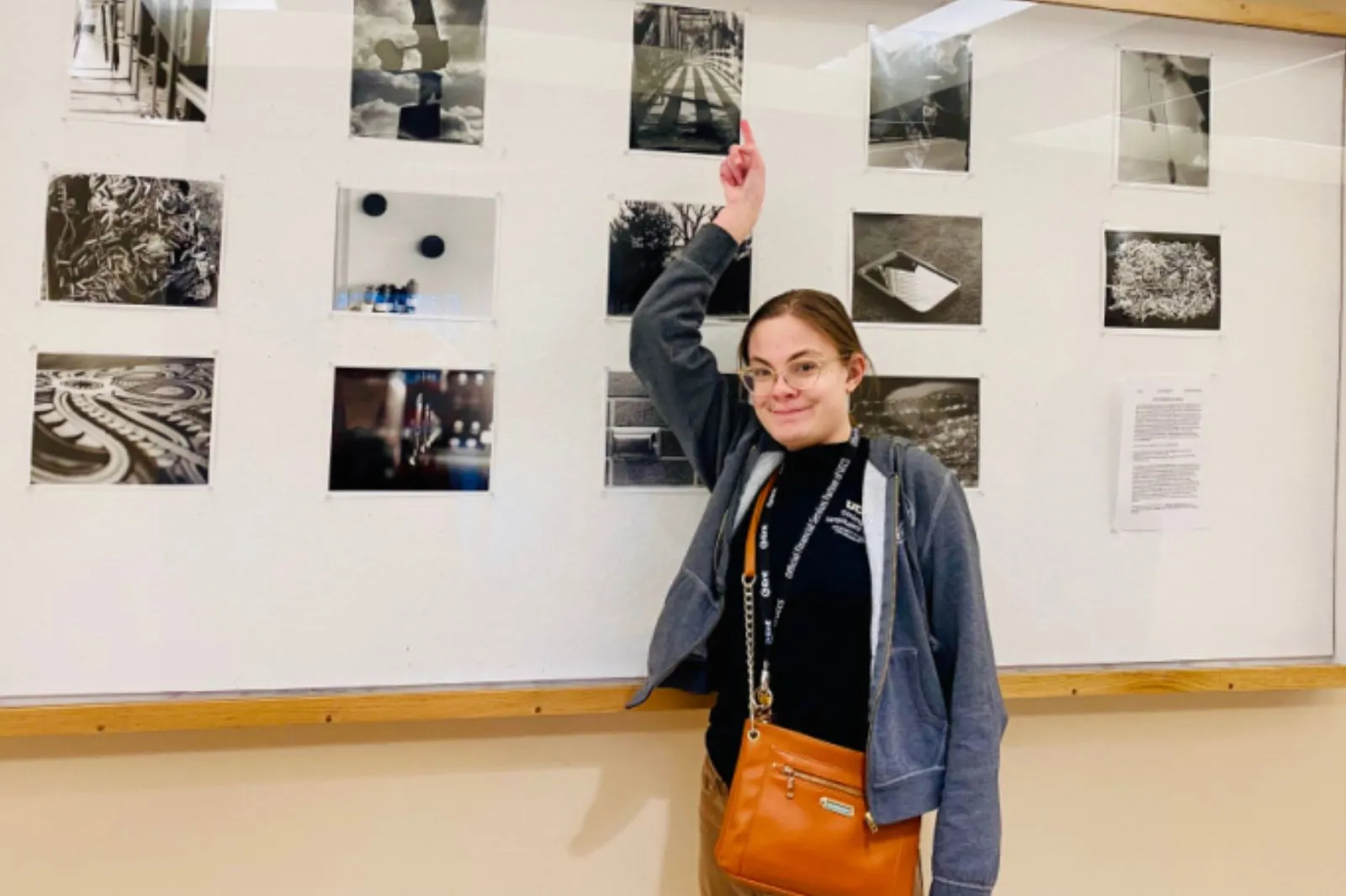 OIS student sending next to a photo gallery wall