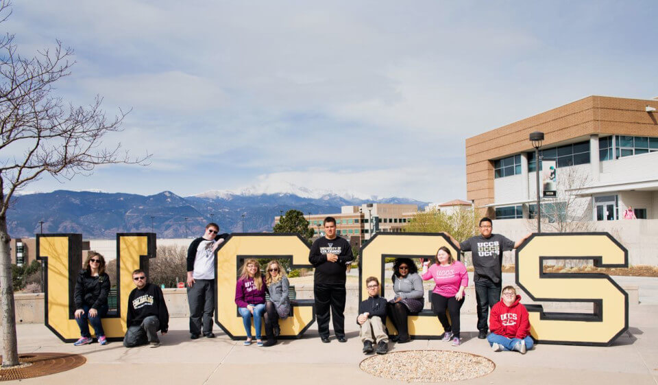 UCCS Letters with students sitting around and on the letters